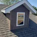 Emergency Roof Repair | Southwest Missouri | Teague Roofing Plus 23 Dark shake style siding and a dormer window on a residential roof