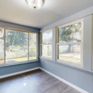 Home | Teague Roofing Plus 57 Enclosed sunroom with wide replacement windows and vinyl flooring