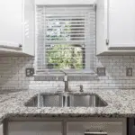 Kitchen window above a sink with tile backsplash