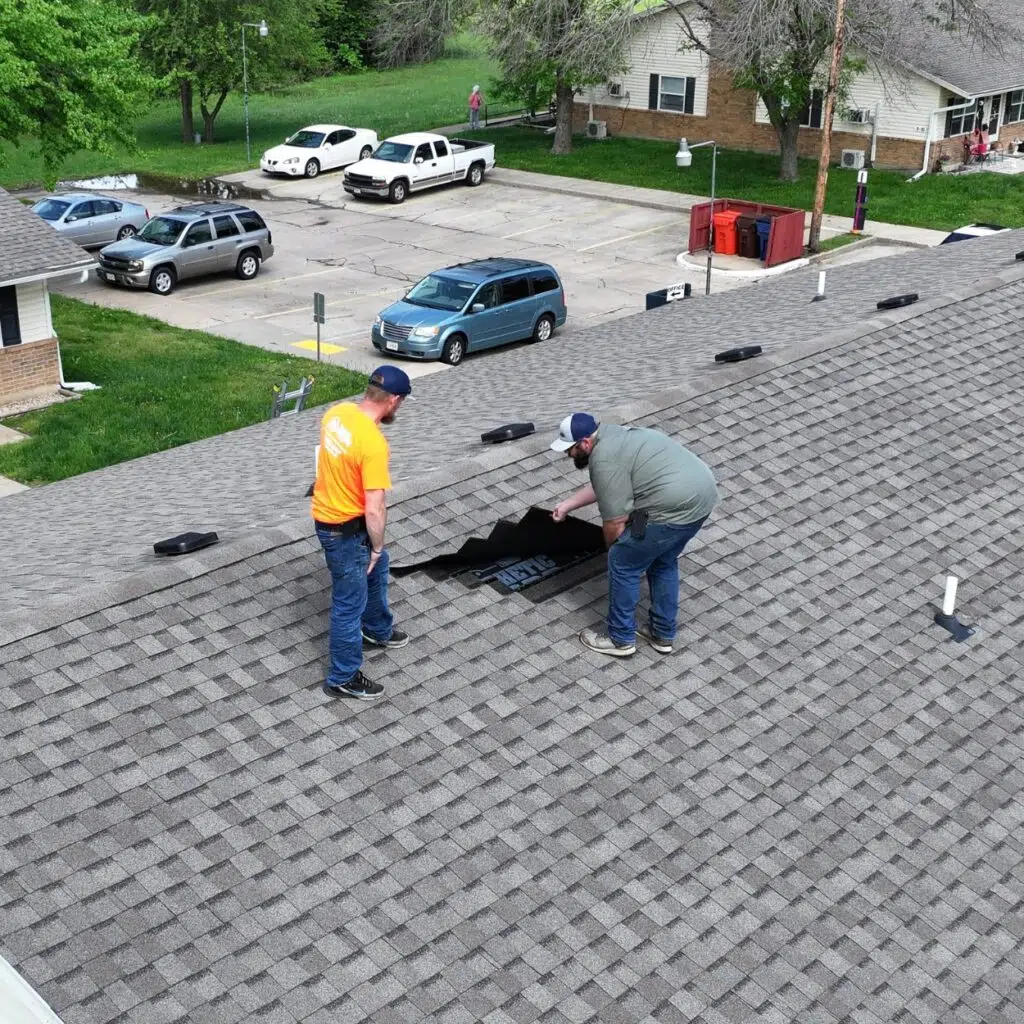 How To Know If Your Spring Storm Repairs Were Done Right 5 Two roofers working on a residential shingle roof repair